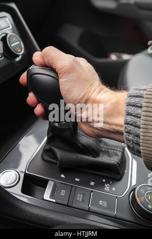 Fahrer-Hand hält Schalthebel des modernen Luxus-Crossover-Auto. Nahaufnahme Foto mit selektiven Fokus Stockfoto