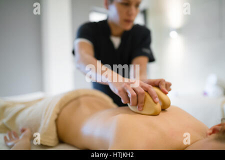 Masseur massieren weiblich auf Bett während sie entspannt Stockfoto