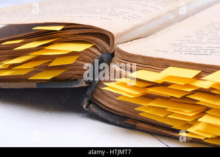 Alte offenes Buch mit Papier Lesezeichen auf Schreibtisch Nahaufnahme Stockfoto