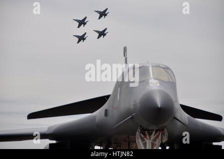 Ein USAF B-1 b Lancer strategischer Bomber Jet Flugzeug sitzt auf dem Display während vier Royal Australian Air Force Boeing f-18 Fighter jets Praxis fliegen in Formation für eine bevorstehende Leistung an der Avalon 2009 Australian International Airshow und Luft-und Raumfahrt & Verteidigung Ausstellung 12. März 2009 in Geelong, Australien.        (Foto von Cohen A. Young /U.S. Air Force über Planetpix) Stockfoto