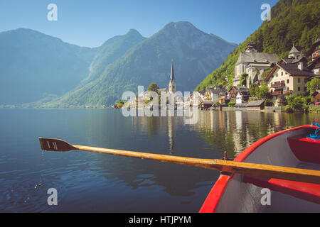 Malerische Postkartenblick auf berühmte Hallstätter See Dorf in den österreichischen Alpen mit traditionellen hölzernen Ruderboot im Sommer, Salzkammergut, Österreich Stockfoto