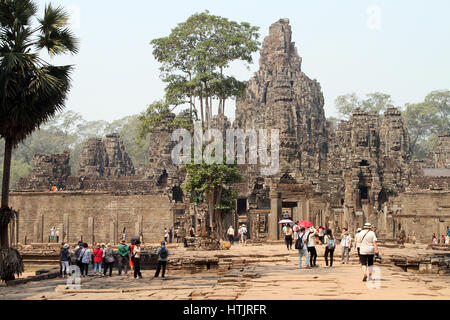 Touristen gehen in Richtung der Bayon-Tempel in Angkor Thom, der ehemaligen Hauptstadt des Khmer-Reiches außerhalb Moderntag Siem Reap, Kambodscha. Stockfoto