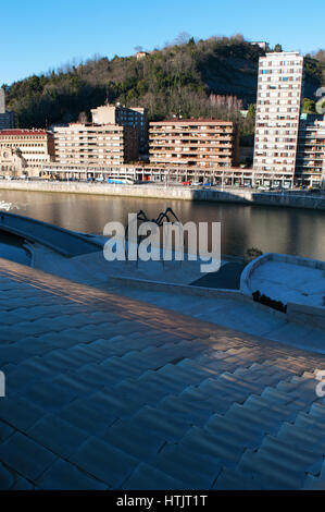 Maman, die Riesenspinne Skulptur von Louise Bourgeois an der Außenseite des Guggenheim Museum Bilbao mit Blick auf die Skyline und den Fluss Nervion Stockfoto