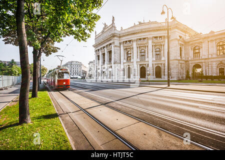 Berühmten Wiener Ringstraße mit historischen Burgtheater (Imperial Court Theatre) und traditionelle rote elektrische Straßenbahn bei Sonnenaufgang in Wien, Österreich Stockfoto