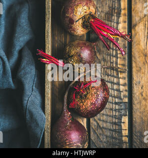 Rohe Bio lila und rote Beete in Holzkiste, quadratische Ernte Stockfoto