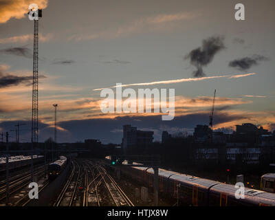 London: Dramatische Himmel über Bahnhof Clapham Junction als Züge ankommen und abfahren Stockfoto