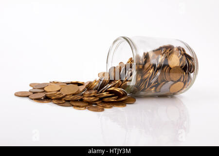 Münzen aus dem Geld-Glas verschütten Stockfoto