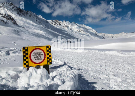 Schild mit der Aufschrift "Chiuso Gesperrt Barre geschlossen". Es handelt sich um eine geschlossene Mountainbike Strecke aufgrund starker Schneefälle fallen und Lawinengefahr in den österreichischen Alpen. Stockfoto