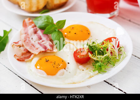 Englisches Frühstück - Speck, Spiegelei und Tomaten. Stockfoto