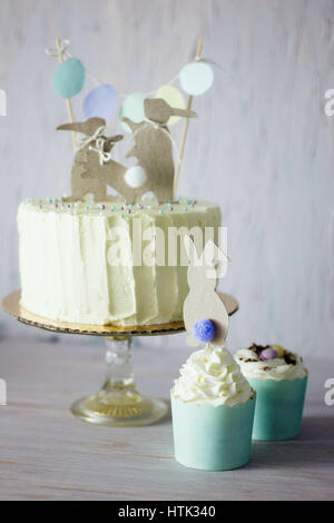 Unter dem Motto Hochzeit oder Geburtstag Osterkuchen, mit Papier-Kaninchen-Silhouetten als Kuchen Topper. Geringe Schärfentiefe. Stockfoto