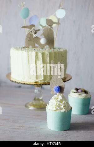 Unter dem Motto Hochzeit oder Geburtstag Osterkuchen, mit Papier-Kaninchen-Silhouetten als Kuchen Topper. Geringe Schärfentiefe. Stockfoto