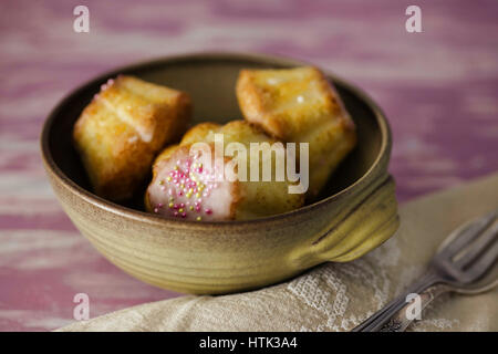 Traditionelle polnische Babka - Ostern Mini Kuchen mit Zuckerguss und Streusel rosa. Stockfoto