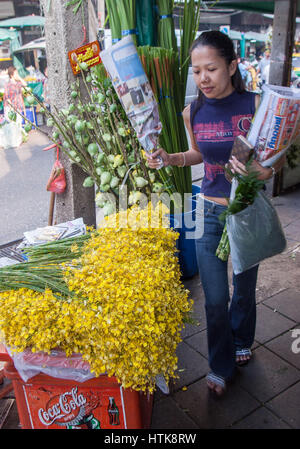 Bangkok, Thailand. 14. November 2006. Ein Besucher mit ihrer Zeitung eingewickelt Blumenstrauß in den berühmten Bangkok Blumenmarkt (Pak Klong Talad). Thailand und der Markt ist ein beliebtes Touristenziel geworden. Bildnachweis: Arnold Drapkin/ZUMA Draht/Alamy Live-Nachrichten Stockfoto