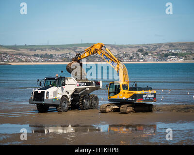 Weymouth, Dorset, UK. 13. März 2017. Bagger bewegen Sand am Strand von Weymouth an einem warmen und sonnigen Frühlingstag an der Südküste. © Dan Tucker/Alamy Live-Nachrichten Stockfoto