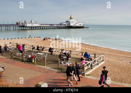 Eastbourne, Vereinigtes Königreich. 13. März 2017. UK-Wetter. Menschen, die genießen, am Strand mit Blick auf Eastbourne Pier in der Frühlingssonne, Eastbourne, East Sussex, UK Credit: Ed Brown/Alamy Live News Stockfoto