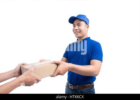 Junger Mann Kurier in blauer Uniform streckt seine Hand aus, um die Pakete zu geben Stockfoto