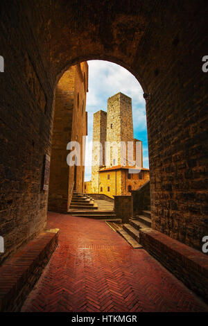 San Gimignano Wahrzeichen mittelalterliche Stadt. Sonnenuntergang aus einem Tunnel auf Türmen Erbe Zentralplatz. Toskana, Italien, Europa. Stockfoto