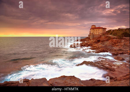 Boccale Burg Wahrzeichen auf Klippe Felsen und Meer auf warmen Sonnenuntergang. Toskana, Italien, Europa. Stockfoto