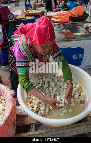 YuanYang, China - 21. Februar 2017: Hani Frau Tofu im lokalen Markt in YuanYang Shengcun zu verkaufen. Hani sind eine der 56 Minderheiten in China und Stockfoto