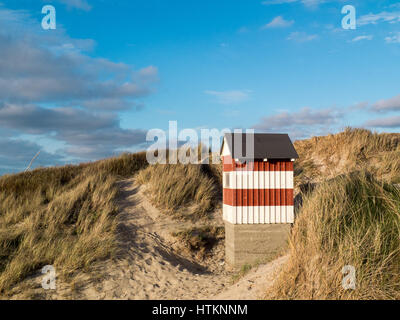 Kleine rot-weiß gestreiften Hütte stehend auf den Strand Dünen mit Blick aufs Meer Stockfoto