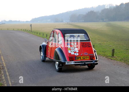 Runnymede, Surrey, UK - 22. Januar 2017: A Citroen 2CV (Deux Chevaux) in rot, verziert mit Aufklebern von Rallyes und Rennen, fahren durch neblige Graf Stockfoto