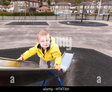 Glückliche Junge kaukasier Junge spielt auf Folie in Spielplatz Model Release: Ja. Property Release: Nein. Stockfoto