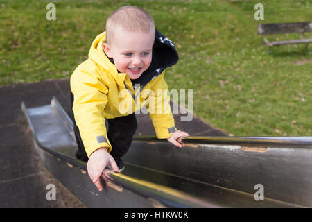 Glückliche Junge kaukasier Junge spielt auf Folie in Spielplatz Model Release: Ja. Property Release: Nein. Stockfoto