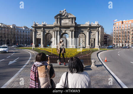 Touristischen posieren für ein Foto vor der Puerta de Alcalá, ein Triumphbogen in der Plaza De La Independencia, Madrid Stockfoto