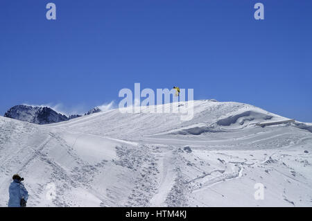 Snowboarder springen im Snowpark im Skigebiet auf Sonne Wintertag. Kaukasus-Gebirge, Region Dombay. Stockfoto