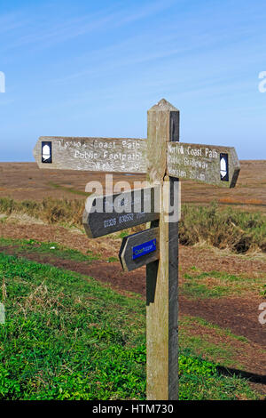 Ein verwittertes Norfolk Coast Path Schild von Salzwiesen in Nord-Norfolk in Stiffkey, Norfolk, England, Großbritannien. Stockfoto