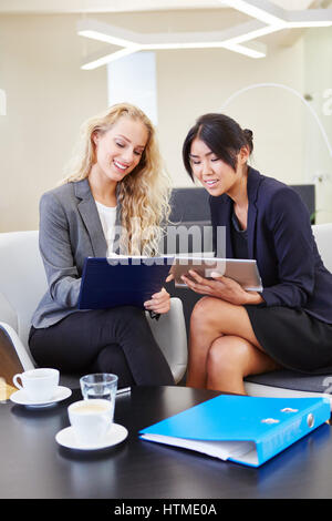 Zwei junge Unternehmerinnen mit Tablet Computer arbeiten zusammen Stockfoto