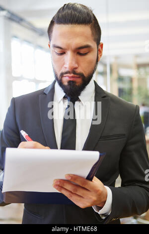 Geschäftsmann mit Checkliste Notizen zur Steuerung Stockfoto