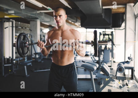 Gut aussehender Mann, trainieren Sie im Fitnessstudio Gewichte heben Stockfoto