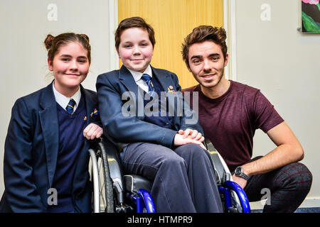 Sperrfrist bis 0001 Dienstag März 14, die Nathan Sykes posiert für ein Foto mit Mimi Kenworthy, 12, und ihre Schwester Beatrice am Barnwood Park Arts College in Gloucester. Stockfoto