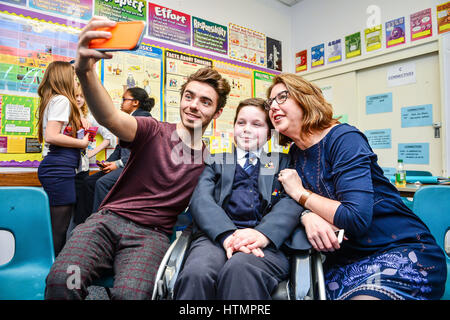 Sperrfrist bis 0001 Dienstag März 14 nimmt Nathan Sykes ein Selbstporträt mit mit Mimi Kenworthy, 12, und ihre Mutter Victoria am Barnwood Park Arts College in Gloucester. Stockfoto