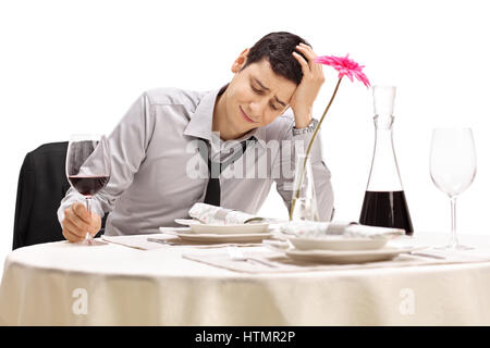 Enttäuscht Geschäftsmann sitzt an einem Tisch im Restaurant hielt seinen Kopf ungläubig isoliert auf weißem Hintergrund Stockfoto