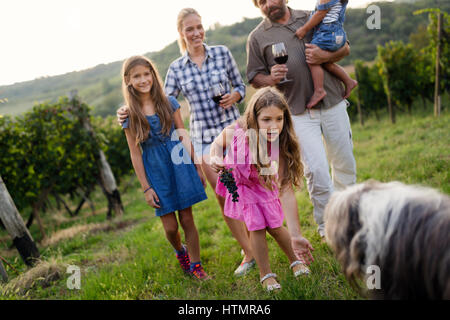 Glückliche Familie mit Hund genießt Spaziergang im Weinberg im Freien in der Natur Stockfoto