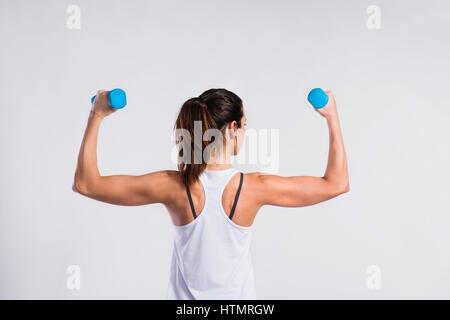 Attraktive junge Fitness Frau mit Hanteln. Studio gedreht. Stockfoto
