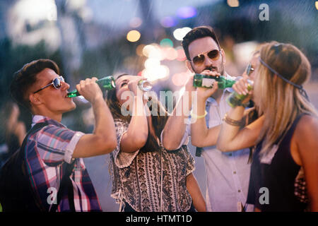 Glückliche Freunde trinken Alkohol im Freien und vor Festival feiern Stockfoto