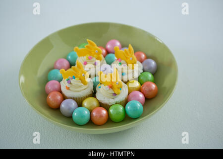 Nahaufnahme der bunte Schokoladeneier mit Tasse Kuchen in Schüssel Stockfoto