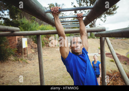 Fit Mann Klettern Klettergerüst im bootcamp Stockfoto