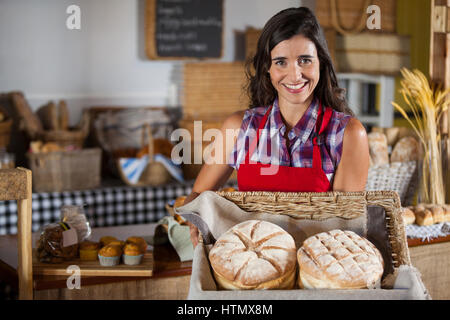 Weibliche Personal holding Weidenkorb Brote am Schalter in Bäckerei Stockfoto