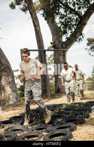 Junge Militär Soldaten üben Reifen-Hindernis-Parcours im Boot camp Stockfoto