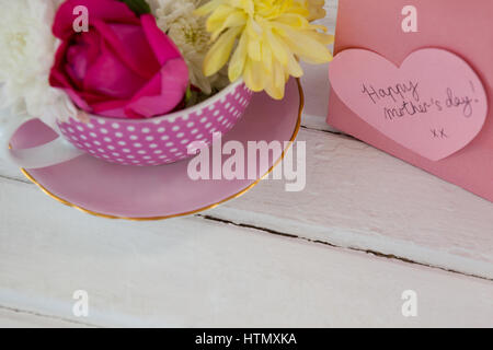 Nahaufnahme der Papiertüte mit Meldung und frische Blumen auf Holzuntergrund Stockfoto