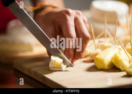 Hand der Mitarbeiter schneiden Käse am Schalter im Markt Stockfoto