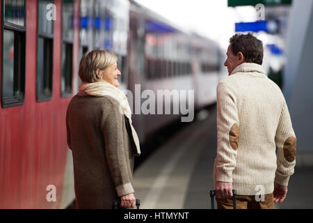Älteres Paar am Bahnhof ziehen Trolley Gepäck. Stockfoto