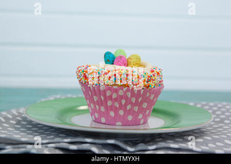 Nahaufnahme von Cupcake mit Ostereiern im Teller auf einer Serviette serviert Stockfoto