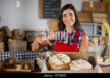 Weibliche Personal holding Weidenkorb Brote am Schalter in Bäckerei Stockfoto