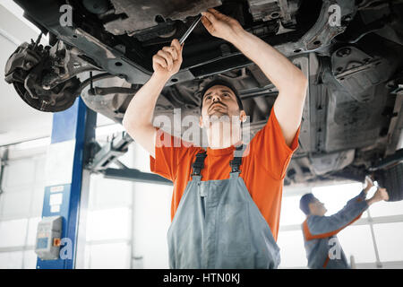 Kfz-Mechaniker arbeitet an Autopflege Stockfoto