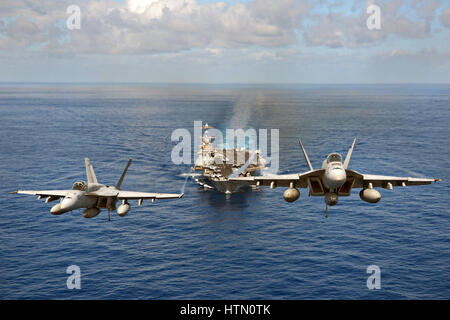 US Navy F/A-18 Super Hornet-Kampfflugzeuge fliegen in Formation vor der USN Nimitz-Klasse-Flugzeugträger USS John C. Stennis 24. April 2013 in den Pazifischen Ozean. Stockfoto